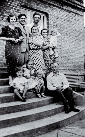 Michał (siedzi na schodach pierwszy z lewej) z rodzicami (mama Felicja stoi pierwsza z lewej, tato Henryk siedzi) przed domem w Pruszkowie, 1938 r.