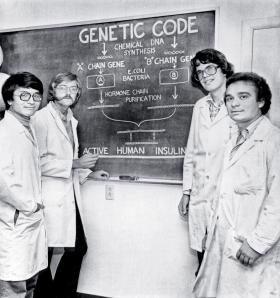 Od lewej: Keiichi Itakura, Arthur D. Riggs, David V. Goeddel i Roberto Crea, naukowcy laboratorium badawczego Genetech, prezentują sposób wykorzystania bakterii E. coli do produkcji ludzkiej insuliny dzięki manipulacjom genetycznym.