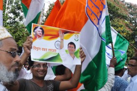 Mężczyzna z plakatem z logo Partii Kongersowej, koalicjanta Trinamool Congress w Bengalu Zachodnim. Na plakacie zdjęcie Rahula Gandhi, syna Sonii Gandhi i sekretarza generalnego indyjskiej Partii Kongresowej.