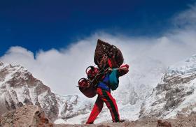 Nepalski Szerpa w drodze na Mount Everest. Wędruje tygodniami, często niosąc ładunek cięższy do niego samego.