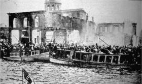 Uchodźcy usiłujący wydostać się ze Smyrny drogą morską. Kilka minut po wykonaniu fotografii kuter widoczny po lewej zatonął w wodach portu.