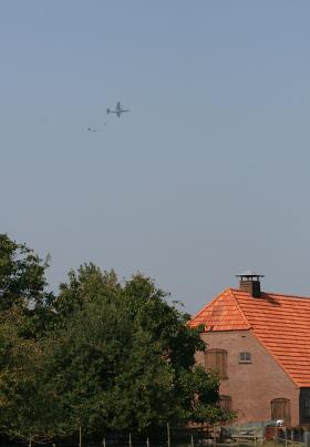 Samolot transportowy i spadochrony nad dachami miasteczka Driel, jak w 1944 r.