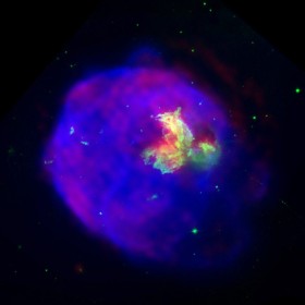 Pozostałośc po wybuchu supernowej LMC N63A. Zdjęcie składa się z z trzech zapisów: w widmie widzialnym (kolor zielony), radiowym (kolor czerwony) i promieniowania rentgenowskiego (kolor niebieski). Pozostałość liczy kilka tys. lat.