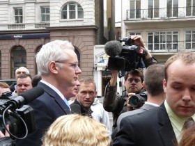 Julian Assange przed rozprawą apelacyjną (pierwszy z lewej) otoczony przez dziennikarzy, przed wejściem do sądu w Londynie.
