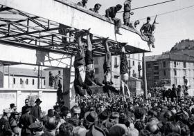 Tłum mediolańczyków wokół powieszonych ciał faszystów (w tym Benito Mussoliniego), rozstrzelanych wcześniej bez sądu podczas próby ucieczki do Szwajcarii, kwiecień 1945 r.