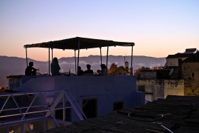 Maroko, gory Rif, Szefszawan. Weści na dachu hotelu Souika relaksują się przy winie i joincie.