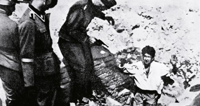 Powstanie w getcie; niemieccy żołnierze opanowują jeden z bunkrów, w których ukrywali się mieszkańcy i żydowscy powstańcy – propagandowe zdjęcie niemieckie z Raportu Jürgena Stroopa.
