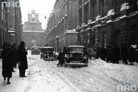 Kiedyś kierowcy mężniej znosili zimę i nie wierzyli w istnienie „drogowców”. Jeśli pojazdy konne i mechaniczne udawało się wypchnąć ze zwałów śniegu, to zima nie była straszna. Kraków, ul. Św. Jana, styczeń 1936 r.