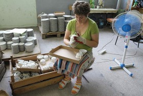 Justyna Połetek, sortuje ceramikę dekorowaną.