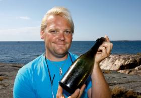 Christian Ekström z jedną z wydobytych z dna morza butelek nadającego się do picia szampana. Z napisów na ich szczelnych korkach wynika, że najstarsze z nich powstały niemal 200 lat temu.