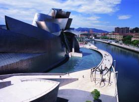 Bilbao – Muzeum Guggenheima. Absolutny punkt zwrotny dla rozwoju współczesnej hiszpańskiej architektury i dla samego Bilbao, o którym turyści być może w innych okolicznościach by nie usłyszeli. Za odważny projekt muzeum odpowiada Frank O. Gehry. Tak powstał dekonstruktywistyczny budynek ze stali tytanowej i szkła. Obiekt bardzo się wyróżnia w okolicy – ze względu na osobliwą, ściągającą wzrok konstrukcję z elementów miękkich, powyginanych, falistych linii i płynnych form. Tę nieregularność widać też w środku, w salach wystawowych, gdzie prezentuje się prace najważniejszych współczesnych artystów. Muzeum jest poza tym pięknie położone – nad rzeką, w której spektakularnie się odbija.