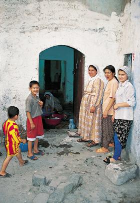 Kurdyjska rodzina przed wejściem do tradycyjnego domostwa w starej części miasta Diyarbakir w płd.-wsch. Turcji