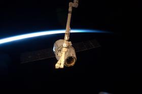 SpaceX Dragon: pierwszy komercyjny - zbudowany przez Space Exploration Technologies Corporation - towarowy statek kosmiczny cumujący do ISS. 25 maja. Zdjęcie ukazuje uchwycenie Dragona przez ramię robotyczne stacji - Canadaram 2.