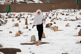Dziewczynka idąca do szkoły przez cmentarz. W Afganistanie cmentarze spotyka się na każdym kroku. Bamian, 2009