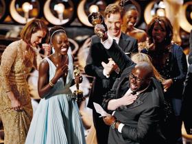 Reżyser „Zniewolonego” Steve McQueen (z prawej) z aktorką Lupitą Nyongo (z lewej) cieszą się z nagrody za najlepszy film tegorocznych Oscarów.