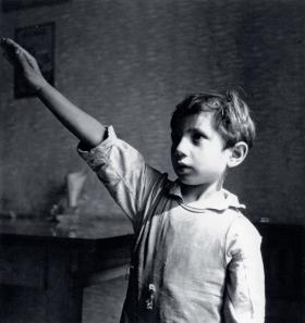 Młody Niemiec ze Śląska demonstruje przed amerykańskim fotografem hitlerowskie pozdrowienie, 1946 r.