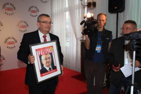 Poseł Andrzej Adamczyk z dumą pokazuje swój zwycięski dyplom.