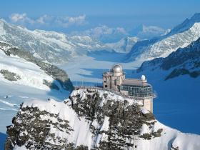 Przełęcz Jungfraujoch w Alpach Berneńskich, zawieszona między szczytami Mönch i Jungfrau. Wznosi się na poziomie prawie 3,5 tys. metrów kwadratowych. Jest nazywana, nie bez powodu, szczytem Europy – naukowcy ulokowali w tych rejonach swoją stację astronomiczną, turyści zaś mogą zatrzymać się na dłużej (w hotelu) albo krócej (korzystając z tarasów widokowych). Zanim tu jednak dotrzemy, czeka nas solidna przeprawa. Solidna i atrakcyjna, podróżujemy bowiem koleją Jungfraubahn, część trasy przemierzymy tunelem. Po drodze liczne przystanki – i szansa, żeby pooglądać jeziora, górskie szczyty (Mönch, Jungfrau, Eiger), ostre stoki, malowniczą panoramę miejscowości Interlaken. Im wyżej i im bliżej celu, tym bardziej przestrzenne krajobrazy.