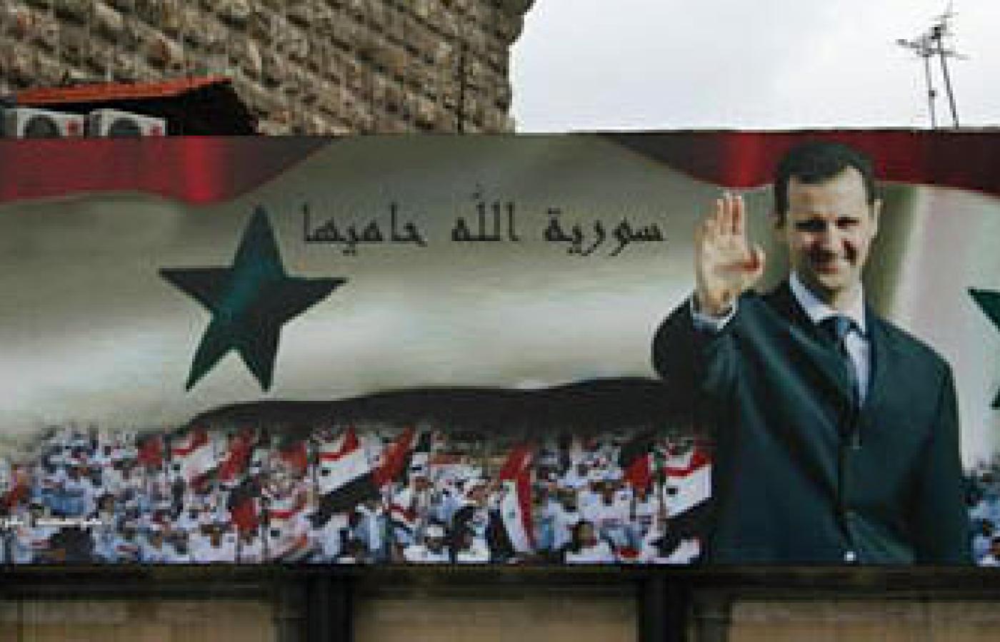 Al-Assad na plakacie z napisem 