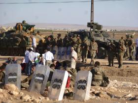 Desperackiej obronie Kurdów z kilkuset metrów przyglądają się tureckie czołgi, stojące zaraz po drugiej stronie granicy.