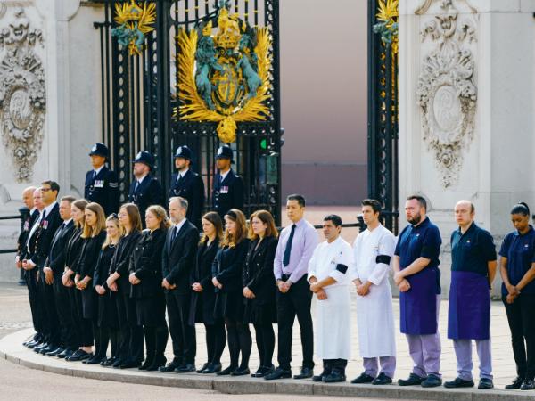 Personel pałacu Buckingham w Londynie żegna królową podczas przejazdu konduktu żałobnego przez miasto.