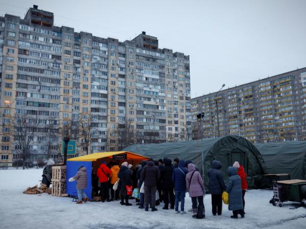 Podczas przerw w dostawie prądu do rządowych punktów pomocy humanitarnej, gdzie ludzie mogą się ogrzać, naładować swoje urządzenia, otrzymać ciepłe napoje i posiłki oraz wsparcie psychologiczne, ustawiają się kolejki chętnych. Kijów, 30 stycznia 2026 r.