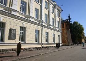 Niedzielni spacerowicze pod domem z tablicą mówiącą o rozpoczęciu przez Włodzimierza Majakowskiego pracy nad poematem o Leninie.