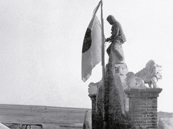 Żołnierz zawiesza flagę japońską w okupowanym mieście Quigihar w Mandżurii, listopad 1931 r.