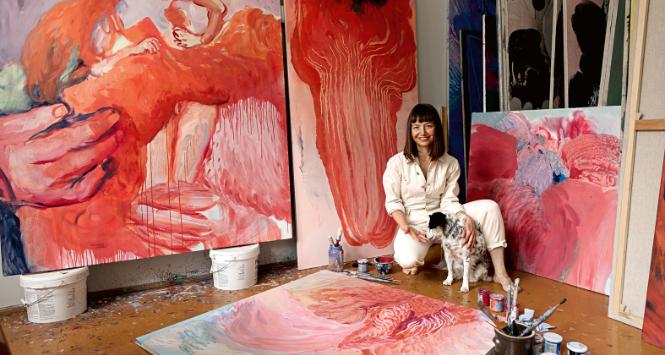 Artystka w swojej gdańskiej pracowni w 2021 roku. Na wprost obraz z projektu „Drapieżne serca” (2021) i Biophilia #5 (2017).  Dalej dwa obrazy z cyklu „Blossoming” (2021). Katarzyna pozuje z ukochaną suczką Nuką.