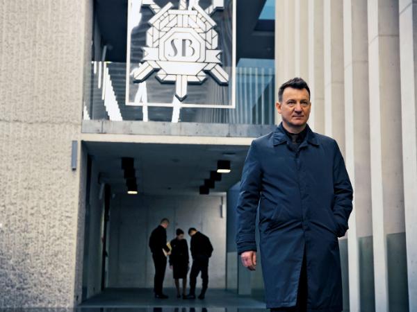Robert Więckiewicz, jako inspektor MO, wychodzi z siedziby SB.