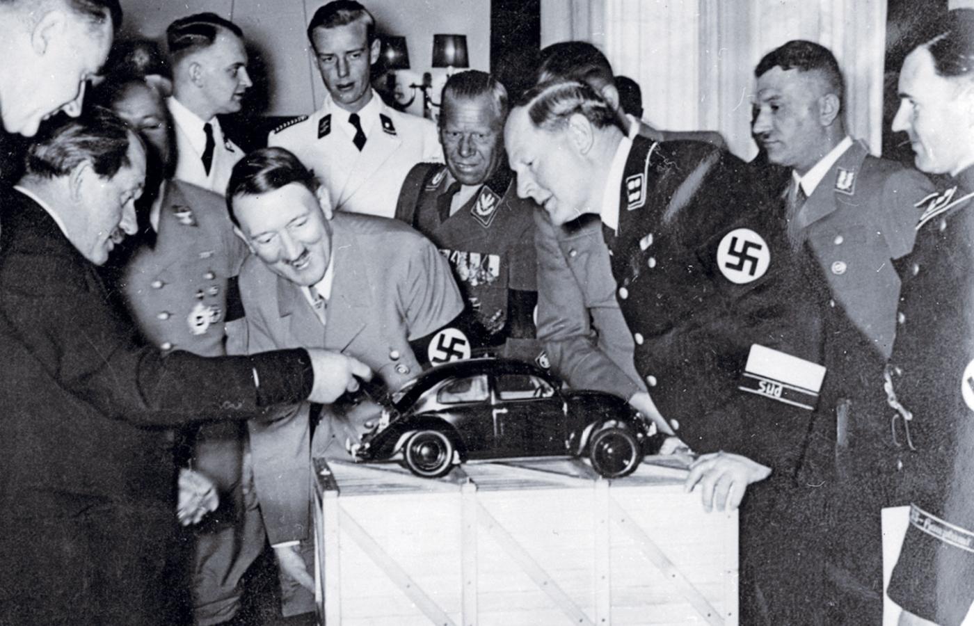 Hitlera cieszy Volkswagen. Znany niemiecki konstruktor pojazdów Ferdynand Porsche (z lewej) demonstruje Führerowi model popularnego samochodu dla ludu, 20 kwietnia 1938 r.