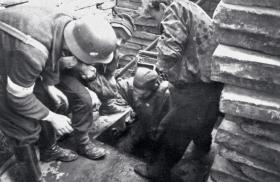 Powstańcy ze Starówki wychodzą z kanału na rogu Nowego Światu i Wareckiej