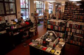 Tajne Komplety, Wrocław, Przejście Garncarskie 21. Dlaczego warto prowadzić księgarnię kameralną?Bo wtedy łatwiej o rozmowę i kontakt z człowiekiem, który jeśli dobrze się poczuje w niszowych, niehałaśliwych okolicznościach przyrody, chętniej zostanie twoim klientem. Prowadzimy prawdziwą księgarnię, a nie stragan z pstrągiem czy sklep z pluszakami i książkami w tle. To się czuje. A jeśli przyjąć, że prowadzenie księgarni to chodzenie po linie, to zdecydowanie milej robić to kameralnie.2. Skąd pomysł na taką, a nie inną nazwę księgarni?Dzięki temu podkreślamy nasz związek z nieoficjalnym nurtem edukacji, a tak właśnie postrzegamy działalność księgarską: nie tylko przez wzgląd na gruntownie wyselekcjonowany księgozbiór, ale również pod kątem ok. 100 organizowanych rocznie wydarzeń (spotkań autorskich, dyskusji, wykładów, koncertów, pokazów filmowych). Tajne Komplety, mimo że mieszczą się na wrocławskim Rynku, są schowane w bocznym Przejściu Garncarskim. To wytchnienie pośrodku zgiełku, wyjście poza kategorię pośpiechu. Jest tu więc kolejny element – tajności – który nam bardzo odpowiada. No i po trzecie: dzięki nazwie księgarni możemy przypomnieć sobie, jak wspaniała jest ta nasza polszczyzna. — Grzegorz Czekański.