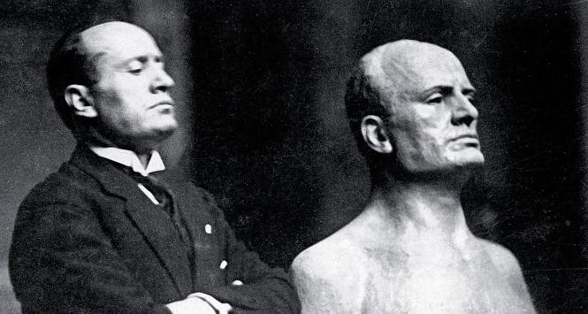 Benito Mussolini pozuje przy swoim popiersiu. Rzeźbiarz wyraźnie uszlachetnił twarz wodza (zdjęcie niedatowane).