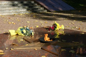 Wiązanki od nowożeńców na płycie upamiętniającej II wojnę światową.