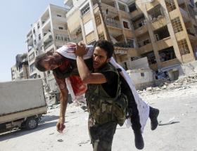 Krew leje się po obu stronach. Na fot. powstaniec WSA wynosi ciało martwego kolegi z objętych walką dzielnic Aleppo, sierpnień 2012 r.