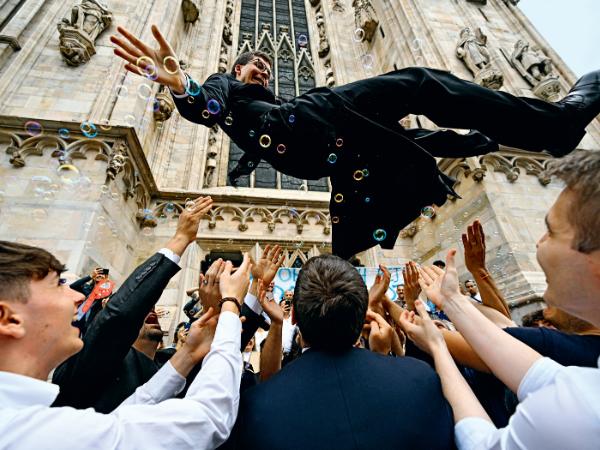 Nowo wyświęcony ksiądz świętuje z przyjaciółmi i rodziną przed katedrą Narodzin św. Marii w Mediolanie.