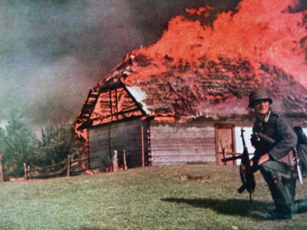 Pożoga i atakujący żołnierz Wehrmachtu na rosyjskiej ziemi, lato 1941 r.