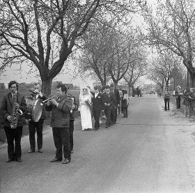 Pierwsze wspólne kroki zawsze pamiętamy. Korowód weselny Zofii i Wiktora Jerglów, orkiestra i goście weselni po uroczystościach kościelnych idą przez całą wieś. Dłudenidowiec, Śląsk Opolski, kwiecień 1973.