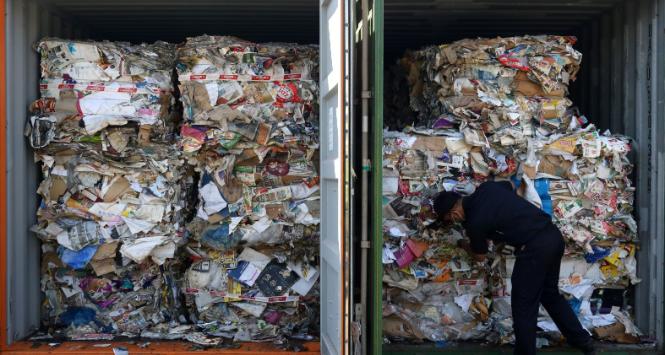 Celnik przeprowadza inspekcję odpadów przesłanych do Indonezji z Australii. Zamiast papieru do recyklingu kontenery pełne były odpadów innego typu, w tym biologicznych.