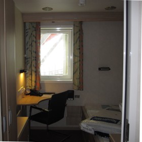 Kajuta. Każdy pracownik ma do dyspozycji niewielką przestrzeń: łóżko , maleńkie  biurko i wielki telewizor. Do tego kabina z wc i prysznicem. Może i spartańskie warunki, ale dwa tygodnie - a tyle trwa zmiana na platformie - da się wytrzymać.