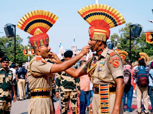 Żołnierze indyjskich wojsk ochrony pogranicza karmią się nawzajem słodyczami w wiosce Wagah na granicy z Pakistanem.