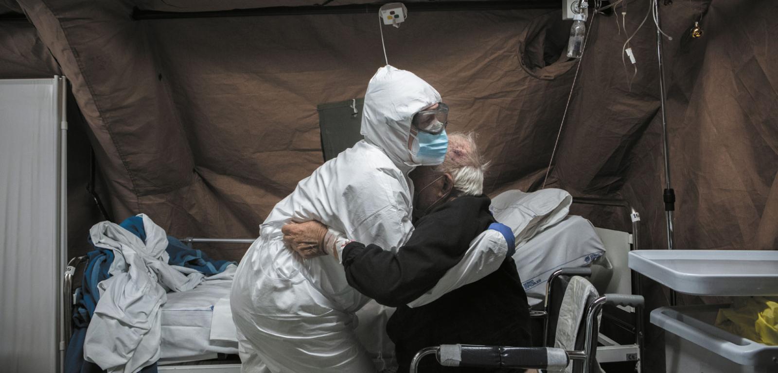 Pielęgniarka z włoskiej armii pomaga pacjentowi z COVID-em przebywającemu w szpitalu polowym w Perugii, który został otwarty w pobliżu przeciążonego szpitala Santa Maria della Misericordia. W grudniu 2020 roku nadal zmagał się z kolejnymi falami pandemii.