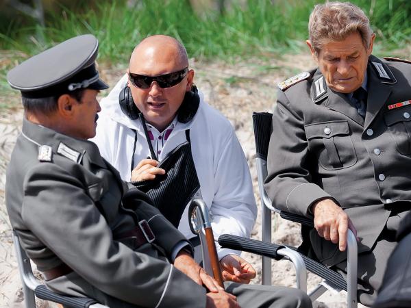 Na planie „Stawki większej niż śmierć”. Od lewej: Emil Karewicz (Herman Brunner), reżyser Patryk Vega i Stanisław Mikulski (Hans Kloss)