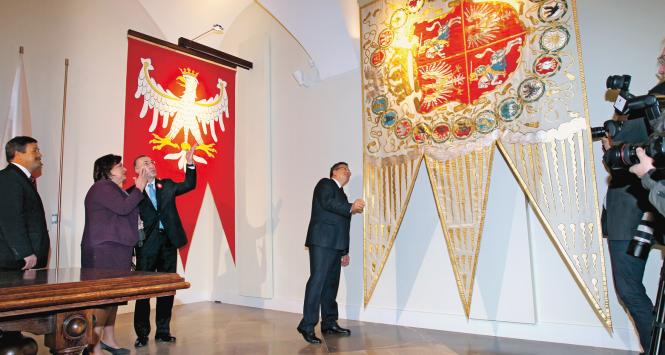 Para prezydencka ogląda repliki Chorągwi Wielkiej Królestwa Polskiego oraz chorągwi Rzeczpospolitej Obojga Narodów.