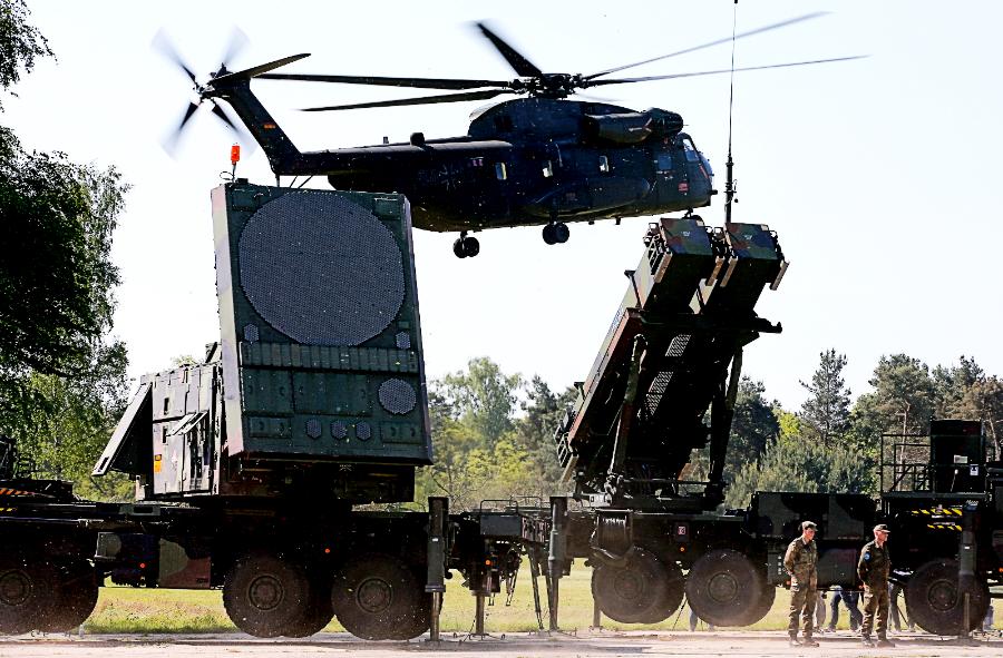 Niemiecki helikopter CH-53 ląduje za należącym do Bundeswehry systemem Patriot.
