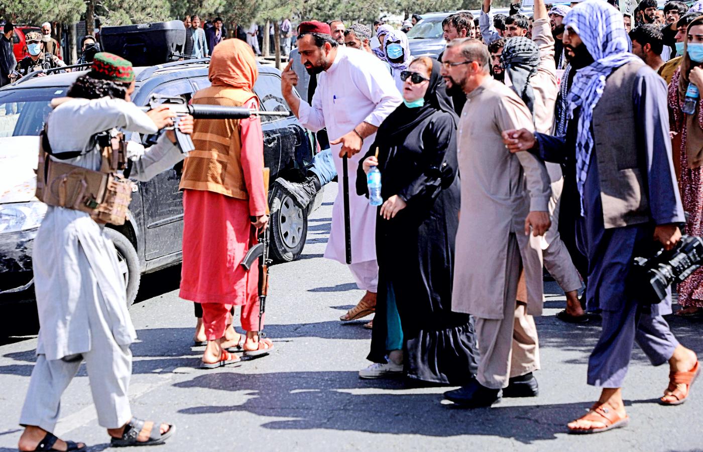 Talib celuje z broni do uczestników antypakistańskiego protestu w Kabulu.