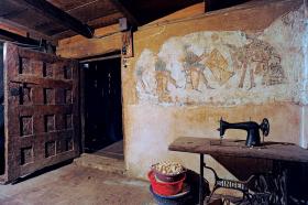 Stara maszyna Singera prezentuje się całkiem nowocześnie na tle XVII-wiecznych drewnianych drzwi i pochodzącego z tego samego okresu fresku.