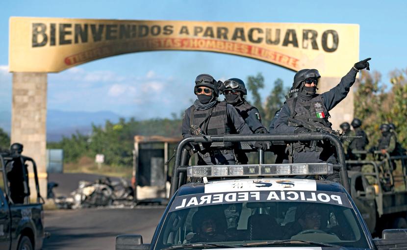 Policja federalna patroluje miasto Paracuaro. W tle barykady przeciwko mafijnym bojówkom.