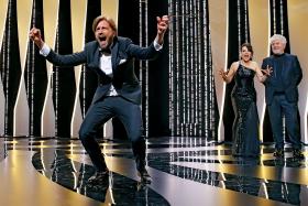 Ruben Östlund cieszy się ze zwycięstwa, z tyłu Juliette Binoche i Pedro Almodovar.